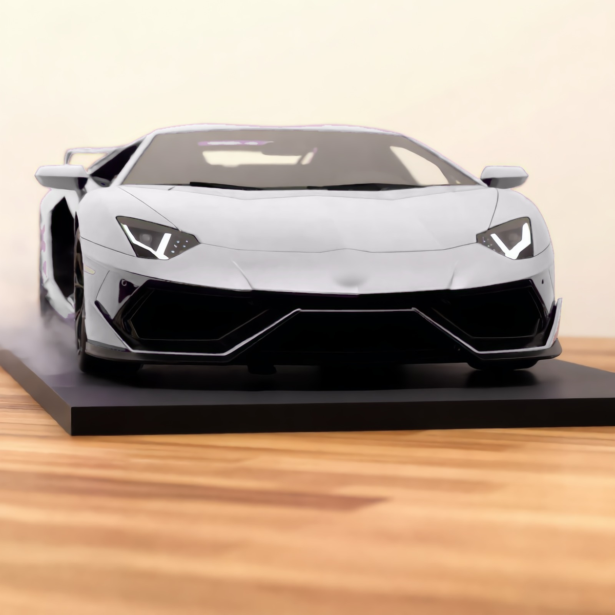 Silver V12 hypercar mist model, front view on a wooden desk